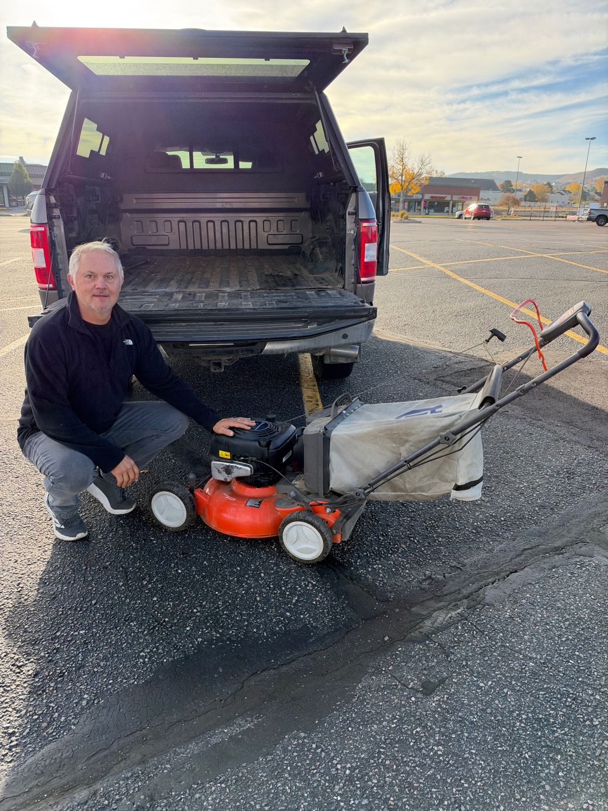 Jim delivering a repaired lawn mower beside his truck
